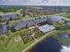Aerial view of a community clubhouse with a pool, lounge area, and manicured gardens with surrounding residential homes at 5268 Pebble Beach Blvd, Winter Haven, FL 33884
