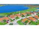 Aerial view of a residential area featuring homes with well-manicured lawns and a beautiful lake at 5268 Pebble Beach Blvd, Winter Haven, FL 33884