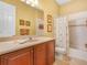 Bright bathroom with wood cabinets and shower-tub combo at 5268 Pebble Beach Blvd, Winter Haven, FL 33884