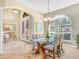 Elegant dining room featuring a glass-top table, chandelier, and stylish decor at 5268 Pebble Beach Blvd, Winter Haven, FL 33884