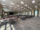 A spacious event space with a stage, tables, chairs, large windows, and neutral carpeting at 5268 Pebble Beach Blvd, Winter Haven, FL 33884
