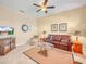 Living room featuring tan walls, a ceiling fan, and a leather sofa at 5268 Pebble Beach Blvd, Winter Haven, FL 33884