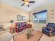 Bright living room with a ceiling fan, window, and a comfortable leather sofa at 5268 Pebble Beach Blvd, Winter Haven, FL 33884