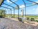 Relaxing screened patio with outdoor furniture, offering stunning views of the golf course and lake at 5268 Pebble Beach Blvd, Winter Haven, FL 33884