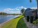 The backyard has a lake view and lush lawn, bordering the screened lanai at 5357 Hogan Ln, Winter Haven, FL 33884
