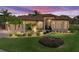 Beautiful home with manicured lawn, stone accents, and elegant lighting under a vibrant sunset sky at 5357 Hogan Ln, Winter Haven, FL 33884