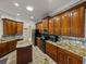 Bright kitchen featuring wood cabinetry, granite counters, stainless appliances, and center island at 5357 Hogan Ln, Winter Haven, FL 33884