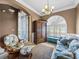Inviting living room featuring a floral sofa, decorative wardrobe, and tiled floors at 5357 Hogan Ln, Winter Haven, FL 33884
