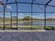 Screened in patio overlooking pond, featuring pavers, exterior lighting, and natural views at 5357 Hogan Ln, Winter Haven, FL 33884