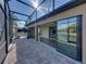 Screened in patio overlooking pond, featuring pavers, and access to the home's interior at 5357 Hogan Ln, Winter Haven, FL 33884