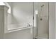 Bright bathroom showcasing a bathtub with tile surround and glass-enclosed shower at 583 Drayton Rd, Winter Haven, FL 33884