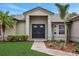 Home's front entrance features a double door and walkway surrounded by landscaping at 583 Drayton Rd, Winter Haven, FL 33884