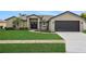 Charming single-story home featuring a manicured lawn and a two-car garage at 583 Drayton Rd, Winter Haven, FL 33884