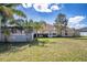 A sunny backyard view features a screened patio and tropical landscaping at 625 Hatchwood Dr, Haines City, FL 33844