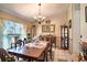Inviting dining room featuring a wooden table with seating for six, a chandelier, and a decorative curio cabinet at 625 Hatchwood Dr, Haines City, FL 33844