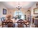 Inviting dining room featuring a wooden table with seating for six, a chandelier, and a decorative curio cabinet at 625 Hatchwood Dr, Haines City, FL 33844