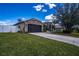 Spacious home with a stone-accented facade, long driveway, and well-maintained landscaping at 625 Hatchwood Dr, Haines City, FL 33844
