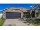 Charming stone facade home featuring an attached garage and well-manicured landscaping at 625 Hatchwood Dr, Haines City, FL 33844