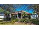 Charming single-story home featuring stone accents, a screened entrance, a well-manicured lawn, and mature palm trees at 625 Hatchwood Dr, Haines City, FL 33844