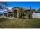 Charming single-story home featuring stone accents, a screened entrance, a well-manicured lawn, and mature palm trees at 625 Hatchwood Dr, Haines City, FL 33844