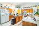 Bright kitchen features white tile flooring, an island, and wooden cabinets at 625 Hatchwood Dr, Haines City, FL 33844