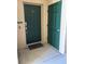Front door of the home entrance with green doors, ring doorbell, welcome mat and the unit number at 703 Eagle Pond Dr # 703, Winter Haven, FL 33884