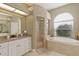 Elegant bathroom featuring a soaking tub, granite counters, and a glass shower at 7327 Bent Grass Dr, Winter Haven, FL 33884
