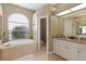 Well-lit bathroom with a soaking tub, granite counters, and white cabinets at 7327 Bent Grass Dr, Winter Haven, FL 33884