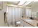 Bathroom featuring a granite countertop, a framed mirror, and a shower curtain at 7327 Bent Grass Dr, Winter Haven, FL 33884