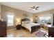 Well-lit bedroom featuring a large bed, wood floors, and neutral decor at 7327 Bent Grass Dr, Winter Haven, FL 33884