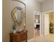 Inviting hallway with decorative mirror and a glimpse into the primary bedroom at 7327 Bent Grass Dr, Winter Haven, FL 33884