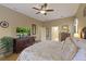 Bright main bedroom with wooden dresser, TV, and entry into bathroom at 7327 Bent Grass Dr, Winter Haven, FL 33884