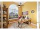 Bright home office with a large window, wood desk and red leather executive chair at 7327 Bent Grass Dr, Winter Haven, FL 33884