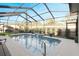 Screened-in pool area with water feature, surrounded by patio and lush landscaping, perfect for relaxation at 7327 Bent Grass Dr, Winter Haven, FL 33884