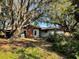 View of backyard featuring mature oak trees and brick chimney at 909 Spirit Lake Rd, Winter Haven, FL 33880