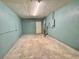 A large, unfinished basement space with concrete floor, pale blue walls, and fluorescent lighting at 909 Spirit Lake Rd, Winter Haven, FL 33880