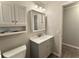 Bathroom with a gray vanity, decorative mirror, and modern lighting at 909 Spirit Lake Rd, Winter Haven, FL 33880