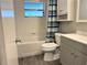 Bathroom featuring a tub with white tile surround and a gray vanity at 909 Spirit Lake Rd, Winter Haven, FL 33880