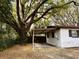 Exterior of home featuring a carport and mature trees, enhancing privacy and shade at 909 Spirit Lake Rd, Winter Haven, FL 33880