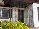 Front entrance featuring security bars, a brown door, and a small garden, enhancing curb appeal at 909 Spirit Lake Rd, Winter Haven, FL 33880