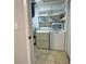 A laundry room featuring a washer and dryer, with shelving above, and tiled floors at 909 Spirit Lake Rd, Winter Haven, FL 33880
