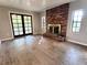 Bright living room featuring a brick fireplace, wood floors, and glass patio doors at 909 Spirit Lake Rd, Winter Haven, FL 33880