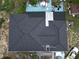 An aerial view of a dark roof on a single-story house, showcasing the landscaping and a partially covered patio at 915 Exmoor Way, Lake Wales, FL 33853