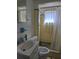 A yellow tiled bathroom with a shower behind a white curtain at 915 Exmoor Way, Lake Wales, FL 33853