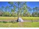 Expansive backyard featuring mature trees, a bridge, and a lush green landscape at 990 Brooke Rd, Fort Meade, FL 33841