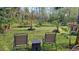 A serene backyard featuring chairs, lush greenery, and charming landscaping elements for relaxation and enjoyment at 990 Brooke Rd, Fort Meade, FL 33841