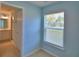 This bedroom features light blue walls, neutral tile floors, and a view of the bathroom at 990 Brooke Rd, Fort Meade, FL 33841