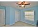 This bedroom features light blue walls, a ceiling fan, closet, and a window with blinds at 990 Brooke Rd, Fort Meade, FL 33841