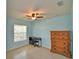 This bedroom features a ceiling fan, tile floors, a window with blinds, a desk and a wooden dresser at 990 Brooke Rd, Fort Meade, FL 33841