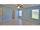 This bedroom features light blue walls, a ceiling fan, tile floors, and a double window at 990 Brooke Rd, Fort Meade, FL 33841